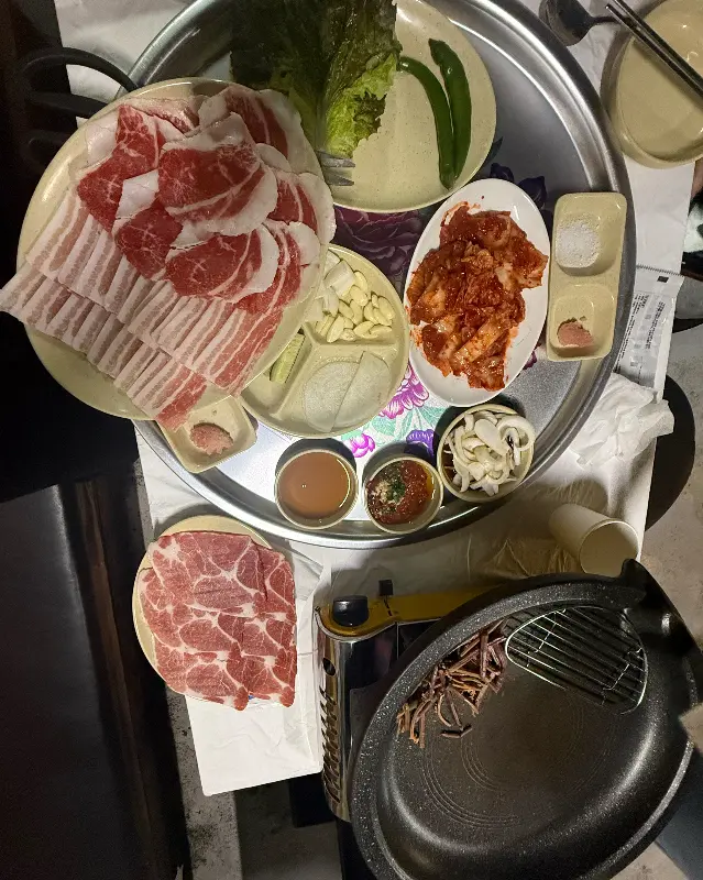 다양한 밑반찬과 신선한 고기 한 상 차림