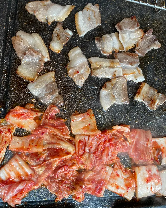 불판 위에서 맛있게 익어가는 냉삼과 김치