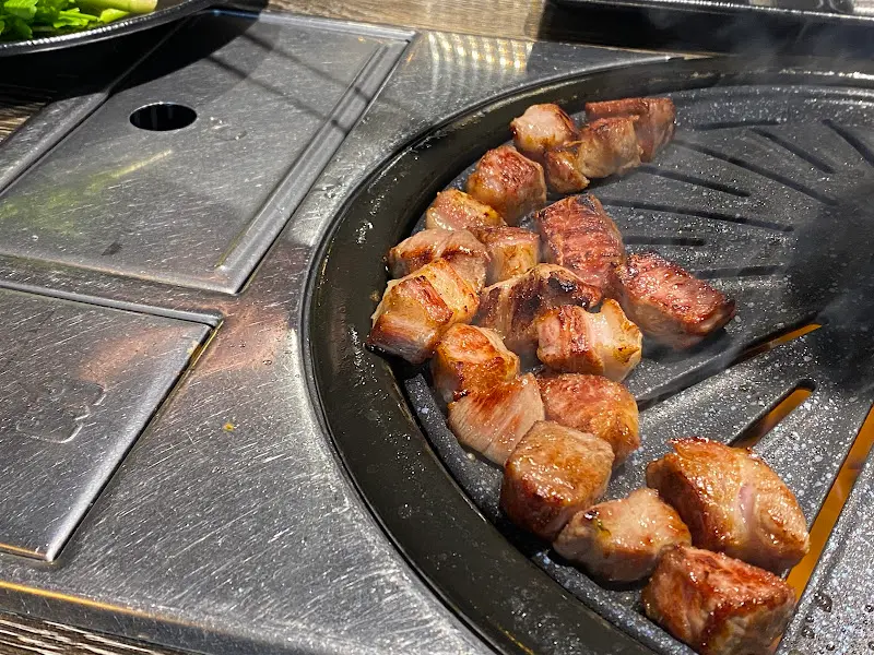 불판 옆에 놓인 구워진 고기 조각들