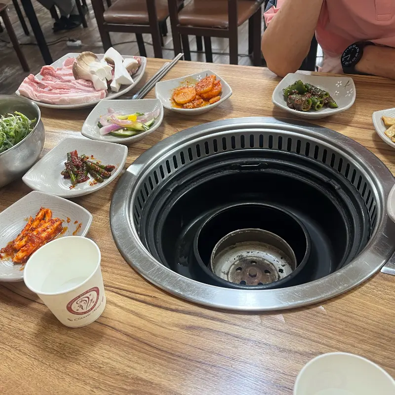 돼지갈비와 밑반찬이 푸짐하게 차려진 테이블