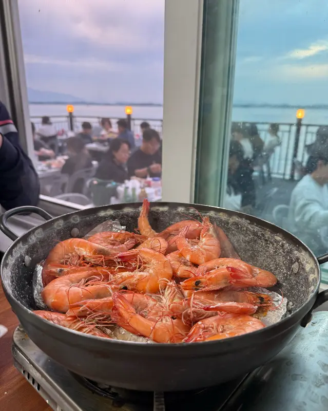 맛있게 익은 새우구이를 배경으로 펼쳐진 남해 바다
