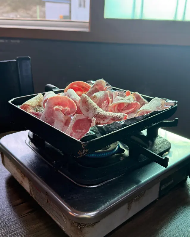 불판 위에서 지글지글 익어가는 냉동 삼겹살