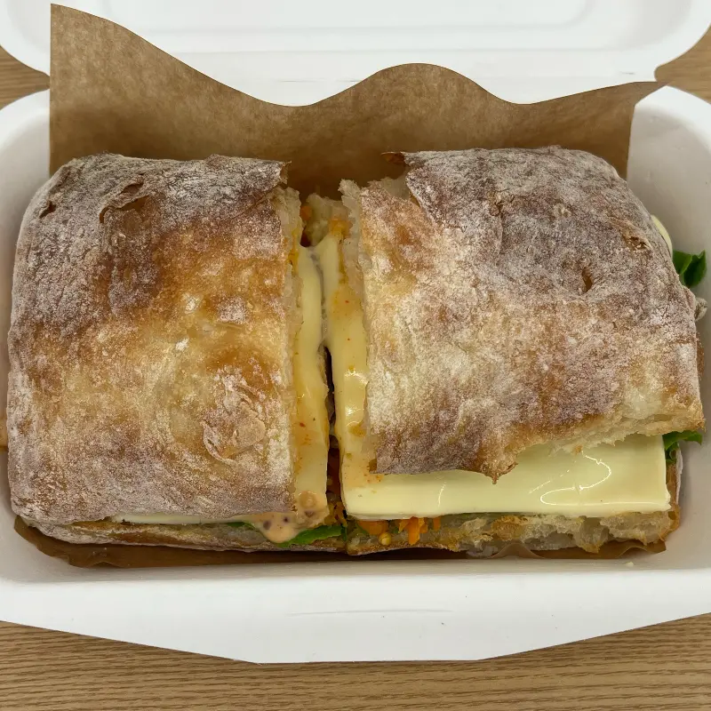 종이 상자 안에 담겨 있는 구운 가지 샌드위치
