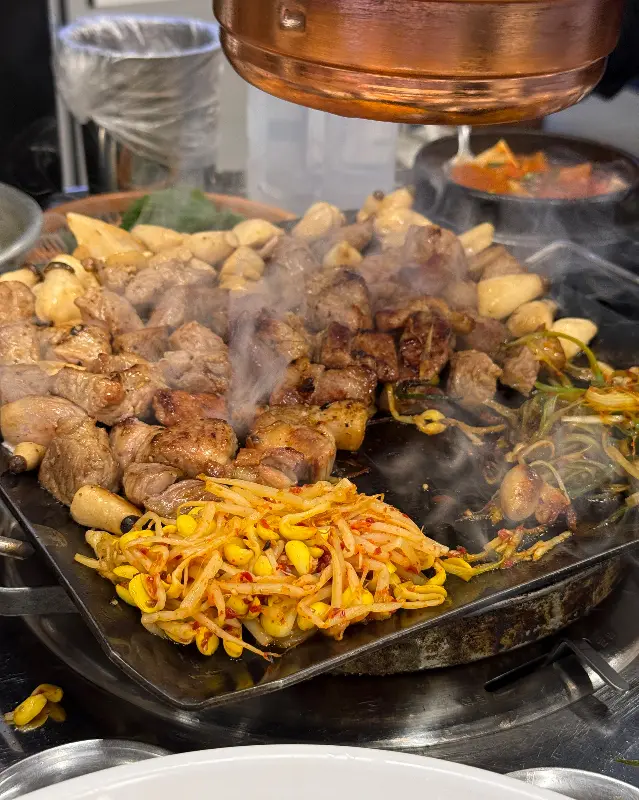 연기가 피어오르는 불판 위의 뒷고기