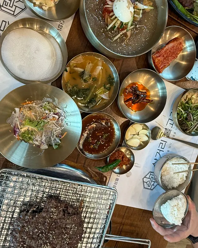 놋그릇에 담긴 정갈한 밑반찬들과 언양불고기, 비빔냉면의 모습