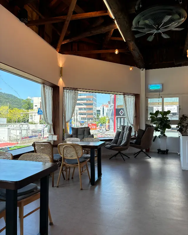 순리당 내부의 테이블 좌석과 통창으로 보이는 순천 시내 풍경