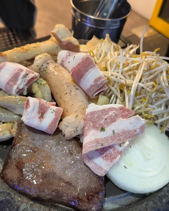 곱창, 우삼겹, 양파, 숙주가 함께 구워지는 모습