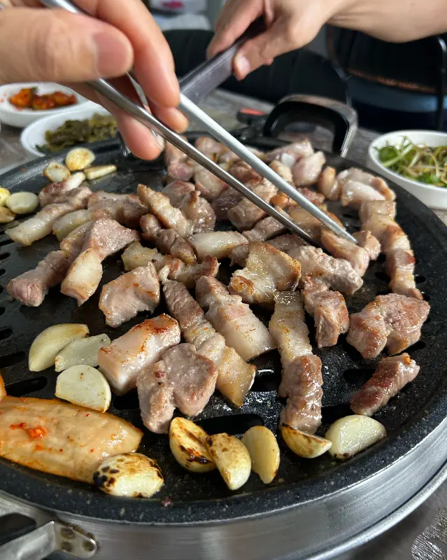 흑돼지와 마늘을 함께 구워 먹는 모습