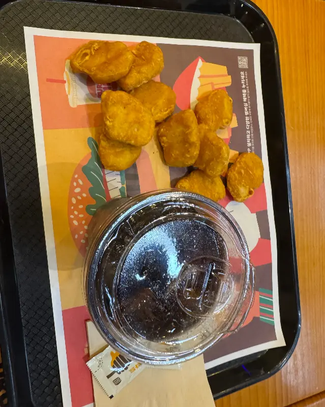 테이블 위에 놓인 치킨 너겟과 콜라