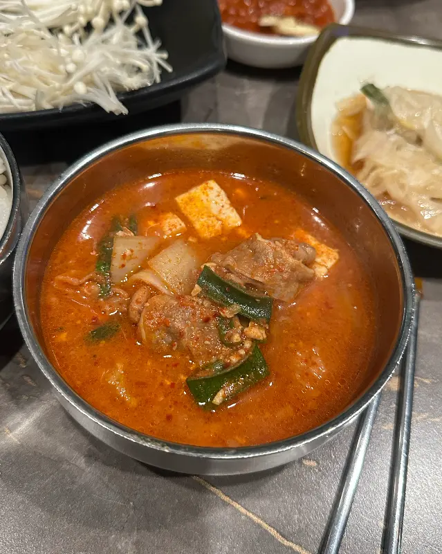 쌈 채소에 고기와 파김치를 올려 먹는 모습