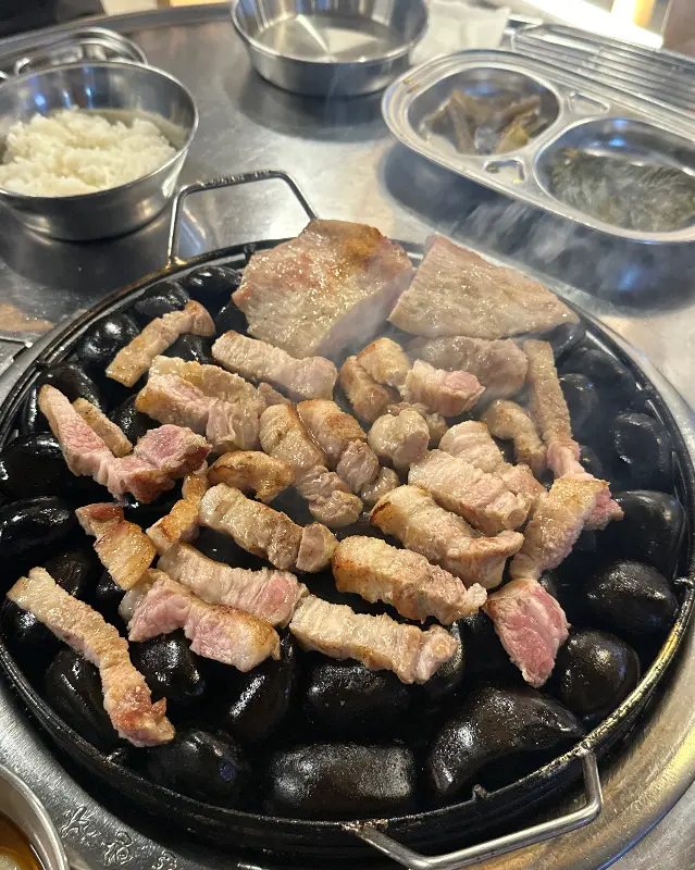 자갈 위에 구워진 삼겹살과 목살