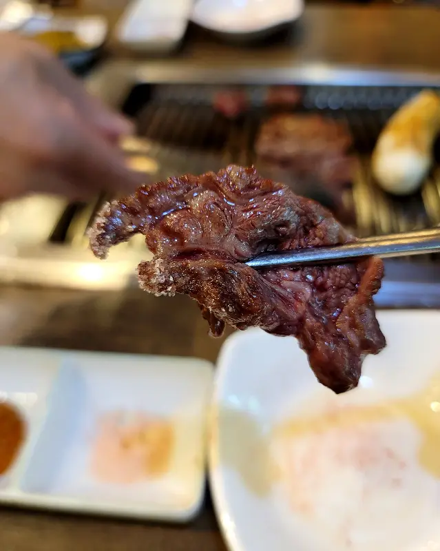 젓가락으로 집어 올린 윤기가 흐르는 한우