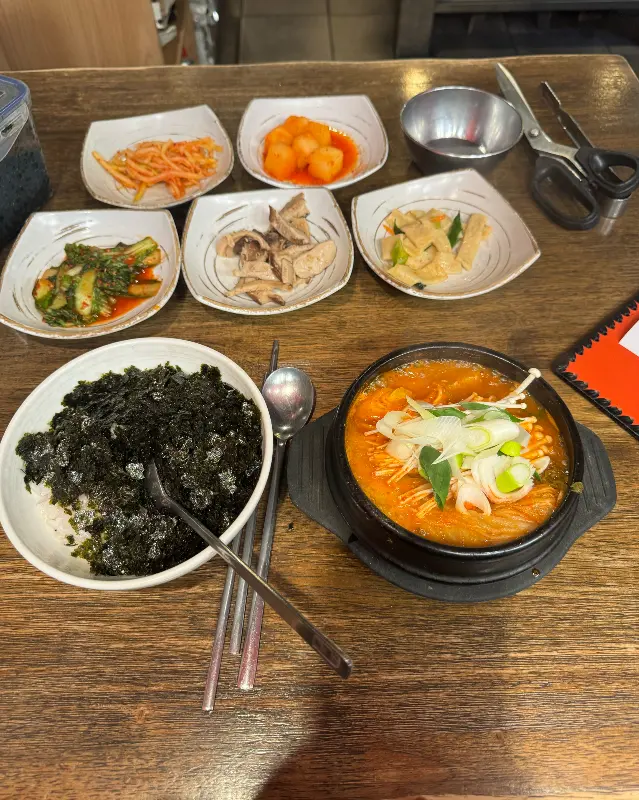 다양한 밑반찬과 김이 모락모락 나는 순두부찌개