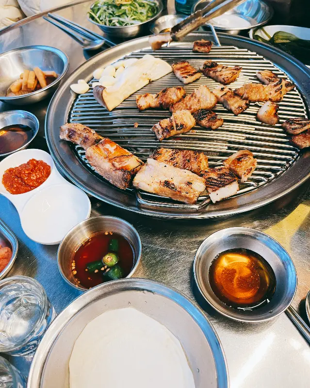 계란찜과 돼지갈비, 반찬이 함께 놓여있는 테이블 사진