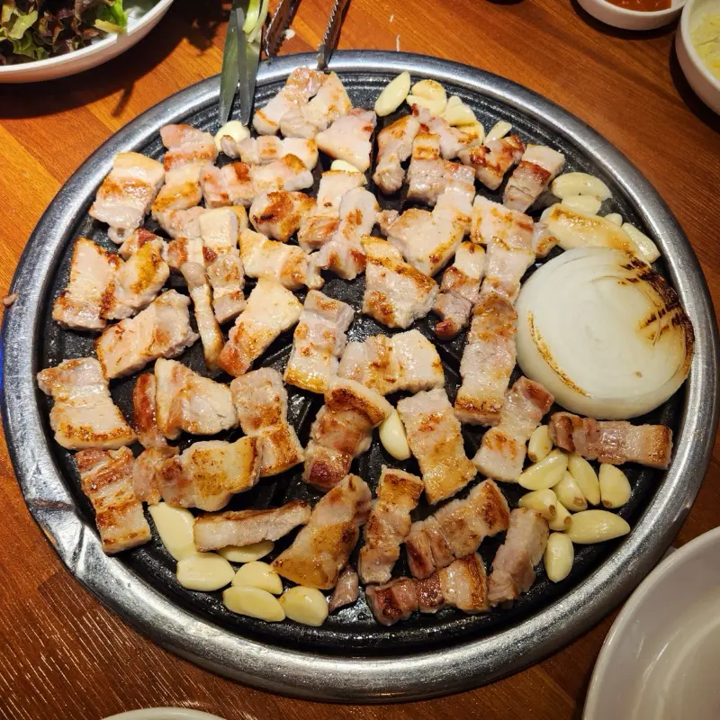 잘 구워진 삼겹살과 마늘, 양파