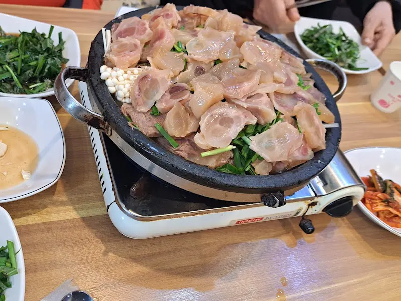 도가니와 수육이 가득 담긴 전골 냄비의 모습