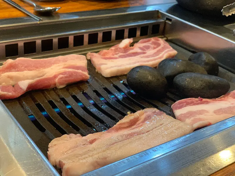 불판 위에서 지글지글 익어가는 삼겹살과 맥반석