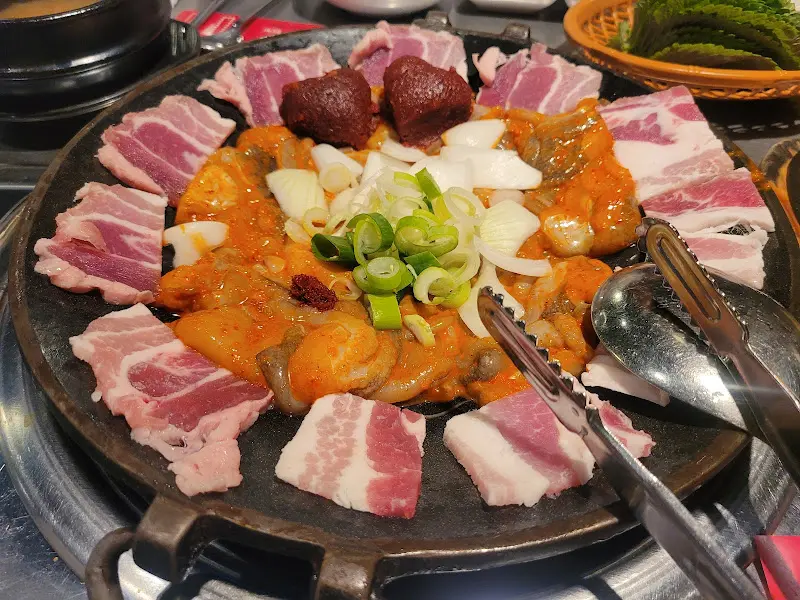 깻잎에 쭈꾸미와 쌈무를 싸서 먹는 모습