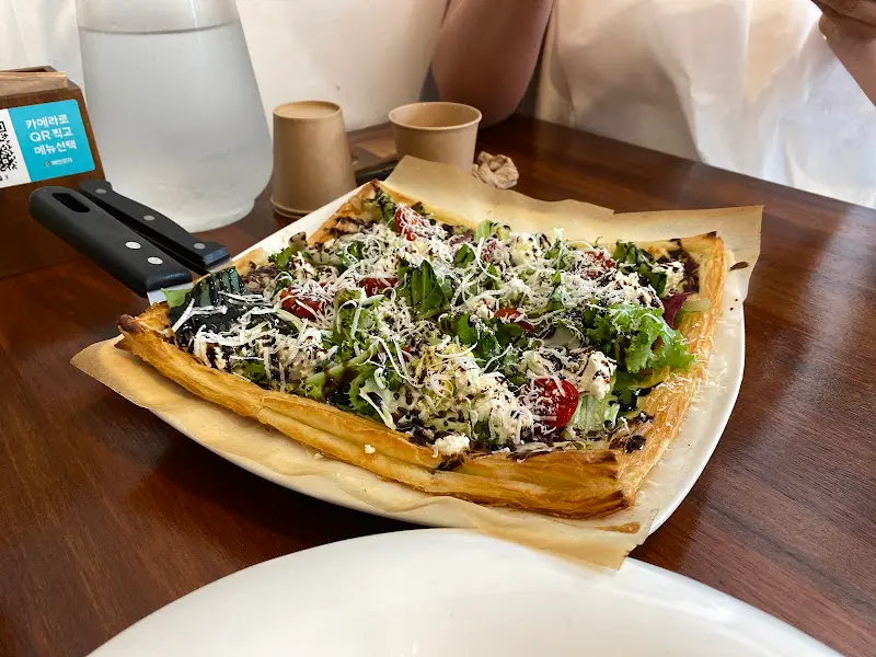 피자 위에 신선한 채소가 듬뿍 올라간 모습