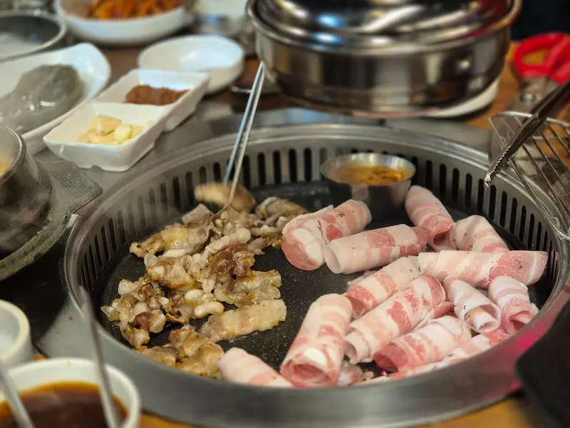 잘 구워진 대패 삼겹살과 익어가는 삼겹살