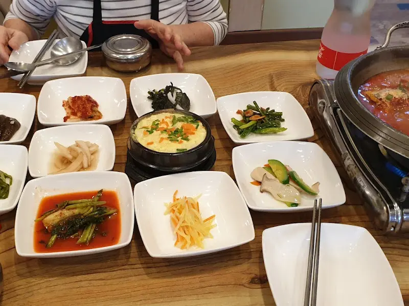 다양한 밑반찬과 갈치조림 뚝배기가 놓인 테이블