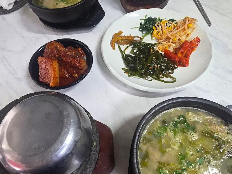 돌솥밥과 추어탕, 고등어조림, 잡채, 나물 등 다양한 반찬이 놓여진 테이블