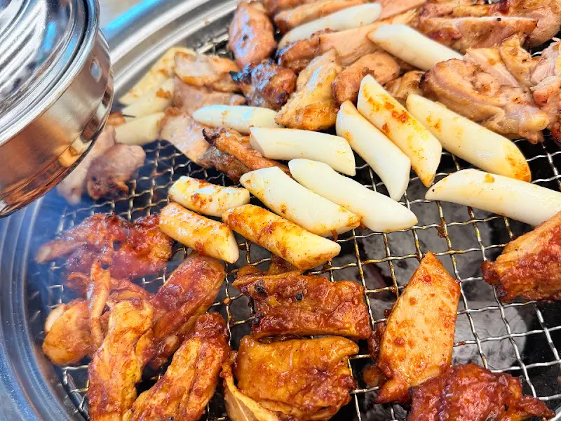 숯불 위에서 맛있게 익어가는 닭갈비와 떡