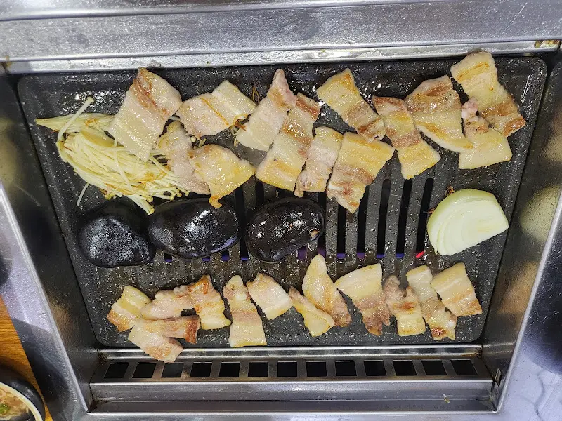 맥반석 위에서 노릇노릇하게 구워진 삼겹살