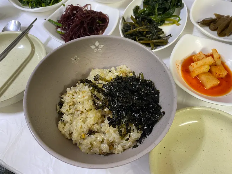 따개비밥과 다양한 밑반찬이 차려진 테이블 전경