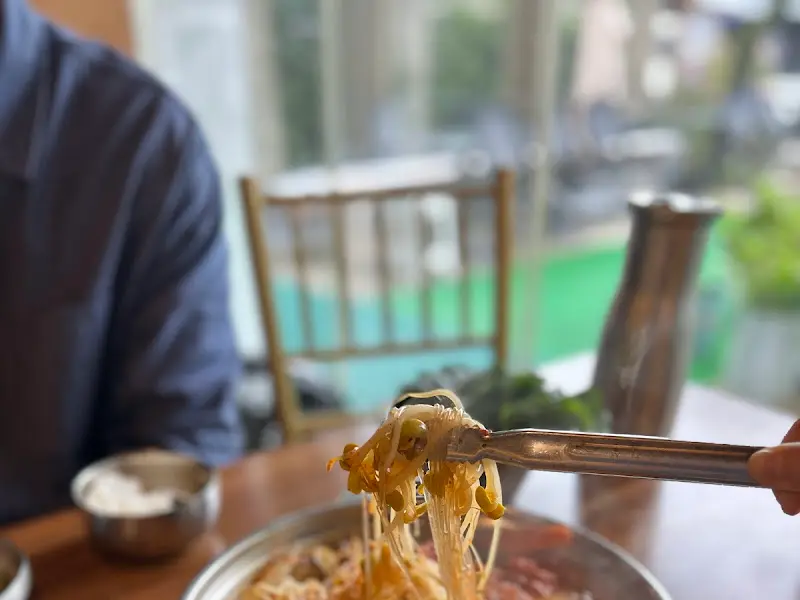 테이블 위 젓가락으로 물갈비 속 콩나물을 집어 올리는 모습