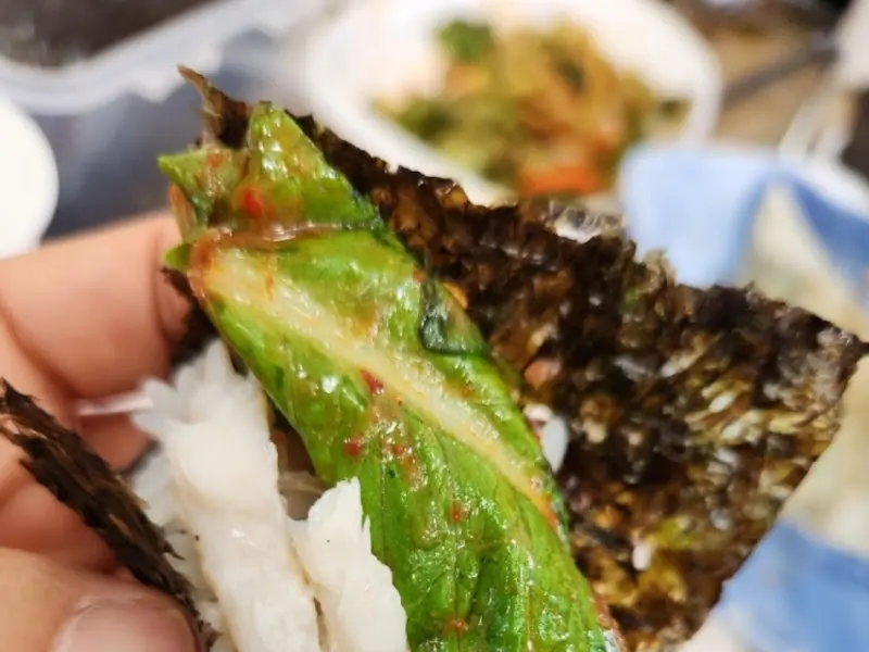 김에 밥과 생선, 깻잎 장아찌를 올려 한 입에