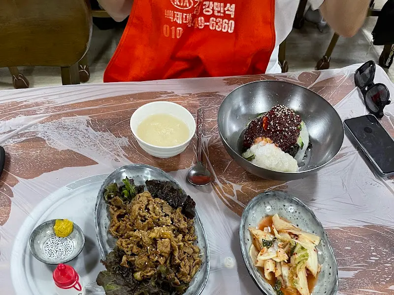 파불고기, 물냉면, 밑반찬이 함께 놓인 테이블