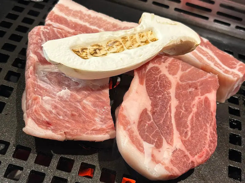 숯불 위에서 익어가는 삼겹살과 버섯