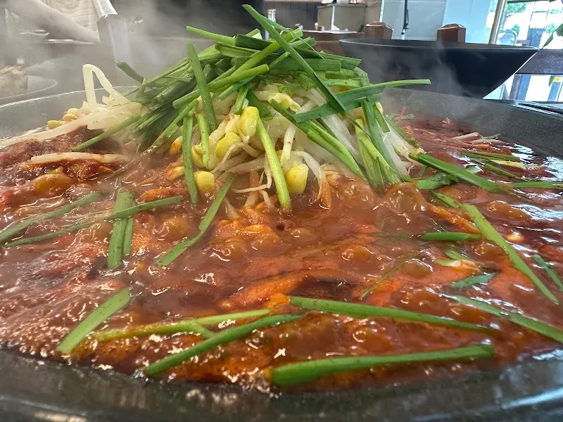 철판 위에 볶아진 낙지와 콩나물, 부추의 모습