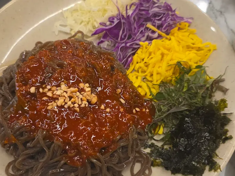 채소가 듬뿍 올라간 쟁반 막국수