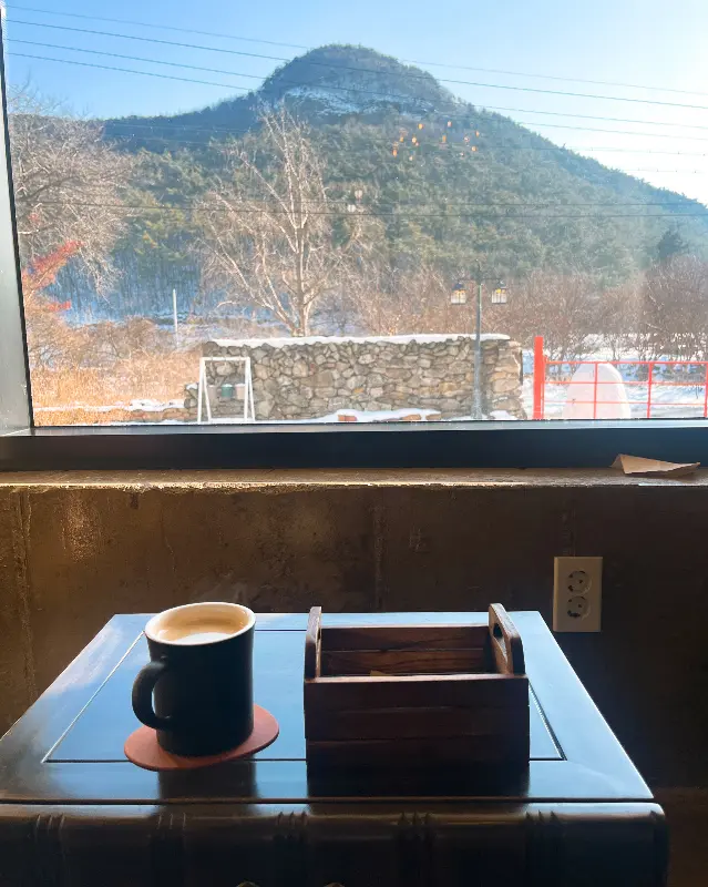 창밖 풍경과 함께 놓인 커피