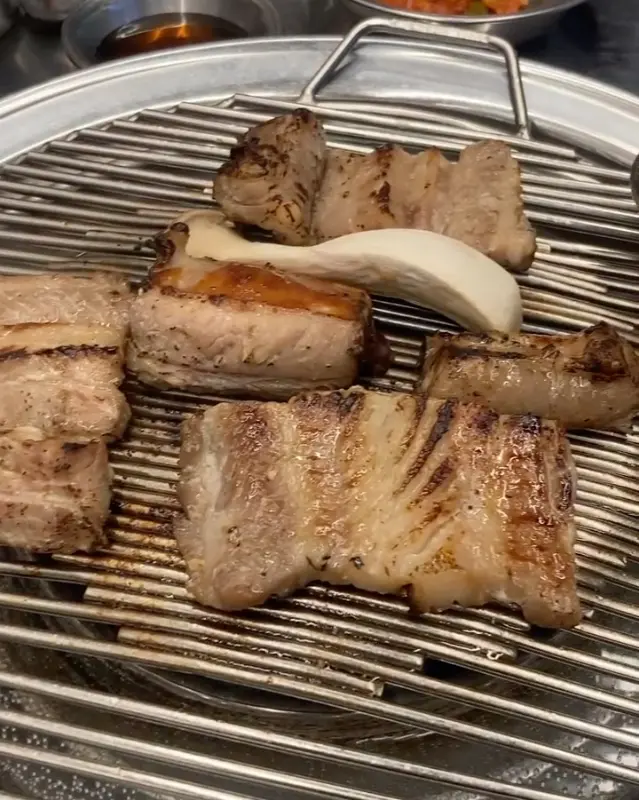 숯불 위에서 구워지고 있는 돼지갈비 사진