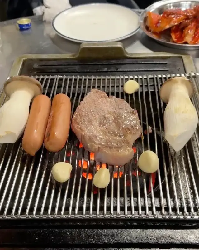 연탄불 위에서 구워지는 소세지와 버섯