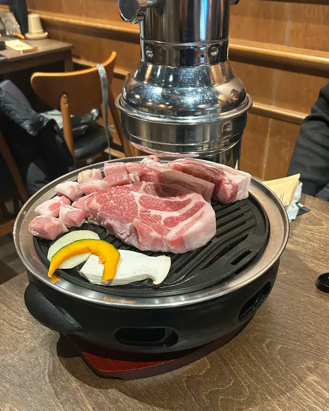 숯불 위에서 익어가는 돼지고기와 버섯