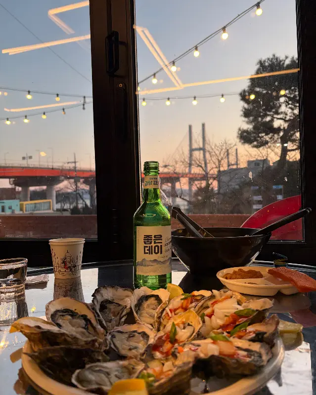 저녁 노을이 지는 창가 좌석에서 음식을 먹고 있는 모습