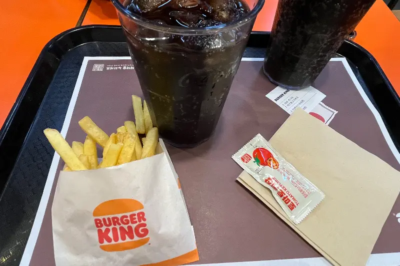 쟁반 위에 놓인 콜라와 감자튀김