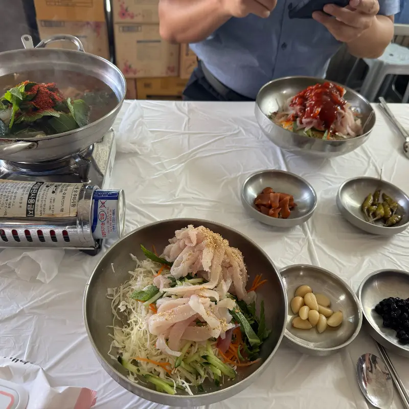 물회와 매운탕, 반찬이 함께 차려진 테이블 사진