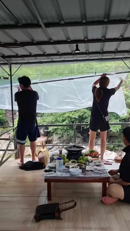 돌담집 평상에서 식사하는 사람들