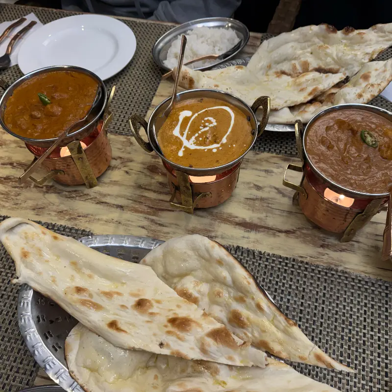 테이블 위에 놓인 세 종류의 커리와 난