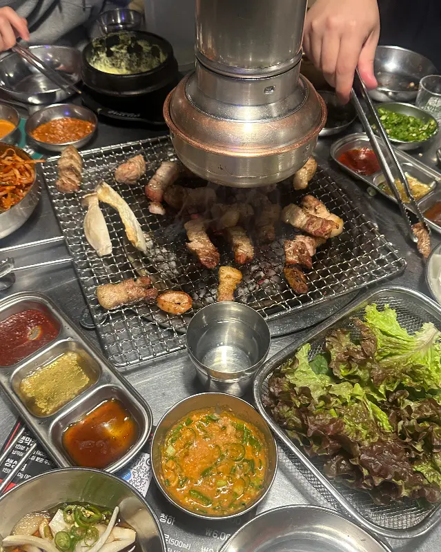 푸짐하게 차려진 테이블 위에 다양한 반찬과 막창이 놓여 있는 모습