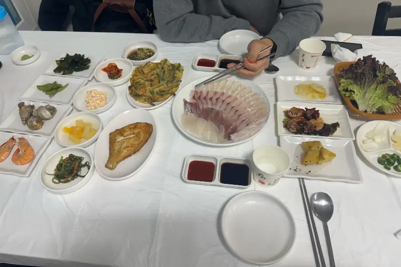 테이블 가득 차려진 밑반찬과 메인 회