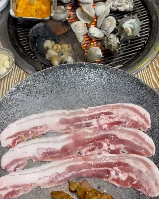 조개와 삼겹살이 함께 구워지는 모습