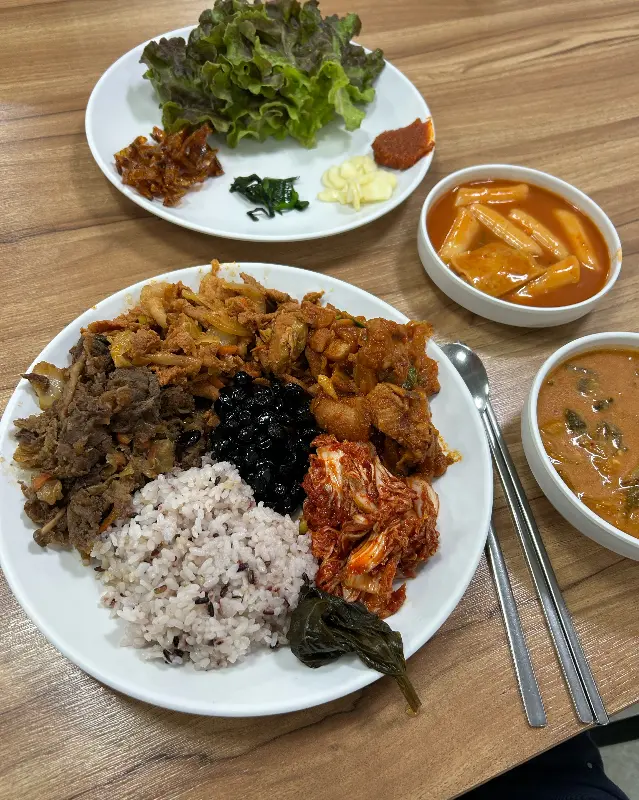 고기, 김치, 나물 등이 푸짐하게 담긴 뷔페식 식사