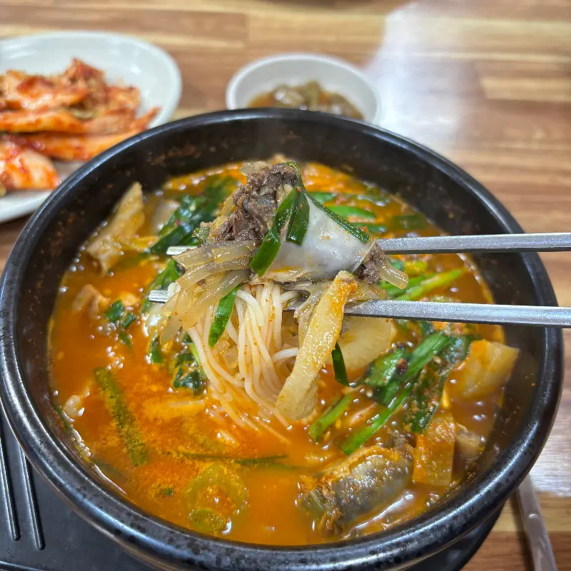 얼큰순대국 속 순대와 면을 젓가락으로 집어올린 모습