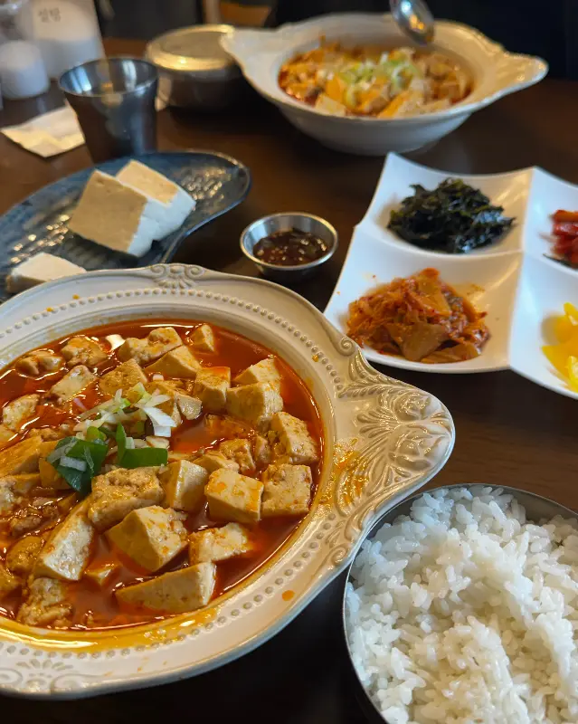 두부조림과 순두부찌개, 밑반찬이 함께 차려진 모습
